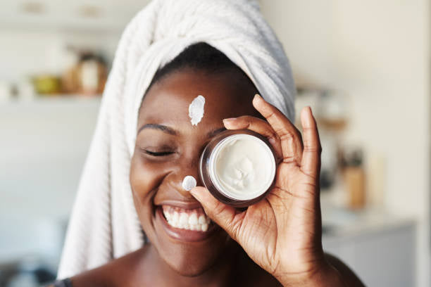 Smiling woman with a jar of moisturizer, showcasing the hydrating and lightweight benefits of DermaSkin’s Caviar Dreams Moisturizer.